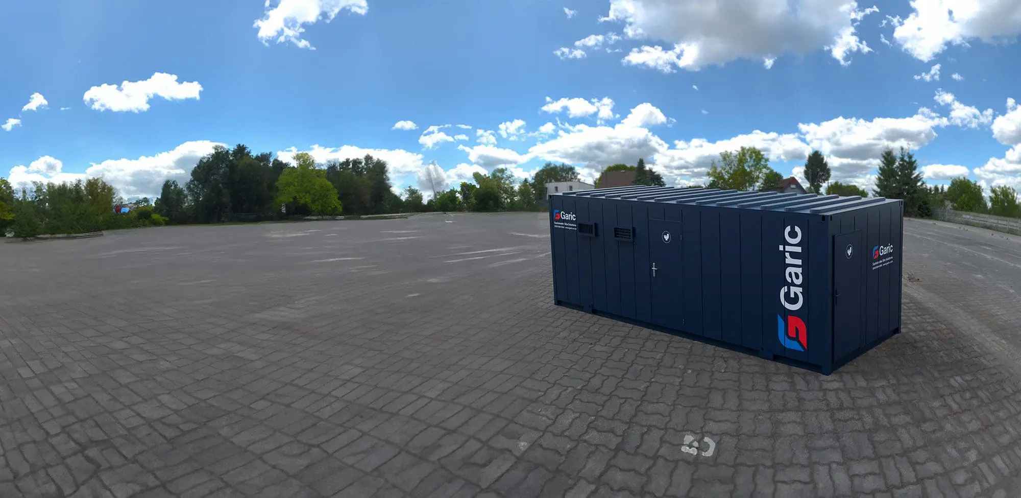 A 4+2 Toilet Block 24 sits on a vast, empty paved lot under a partly cloudy sky.