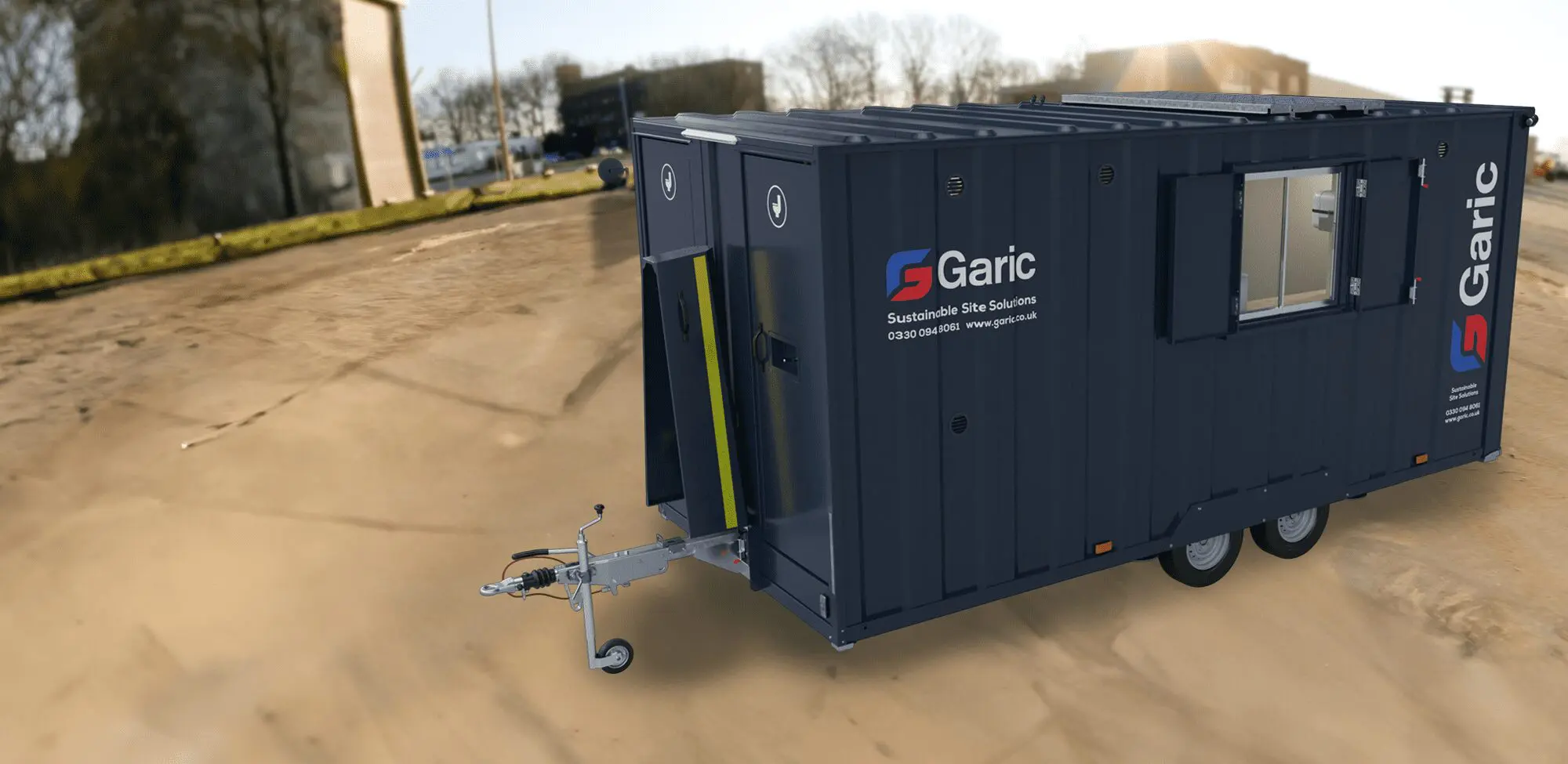 Armadillo 18 Eco site cabin trailer with windows and brand logo parked on a construction site.