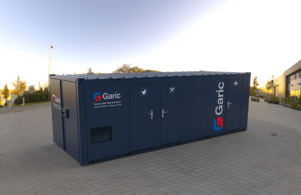 Large blue Combi Cabin 24 portable site unit with multiple doors, placed on a paved outdoor area under a clear sky.