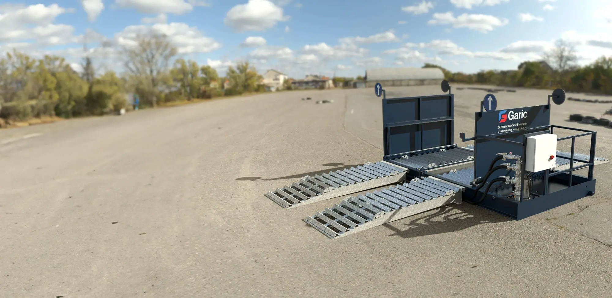 The Enviro Wheel Wash 14 is a portable unit with metal ramps and hydraulic controls, designed for setup on empty outdoor paved areas.