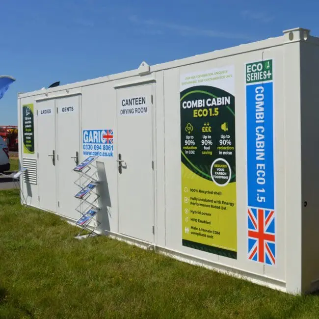 White portable building with UK flag, labeled “Combi Cabin ECO 1.5” and “Ladies,” “Gents,” and “Canteen.”.