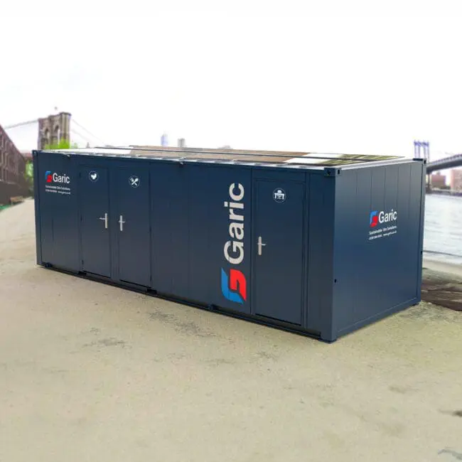 Combi Cabin 24 Eco portable unit with three doors, set outdoors near a bridge and water in an urban area.