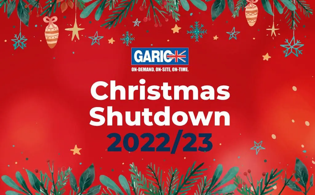Red festive background with text Christmas Shutdown 2022/23 and holiday decorations and greenery.