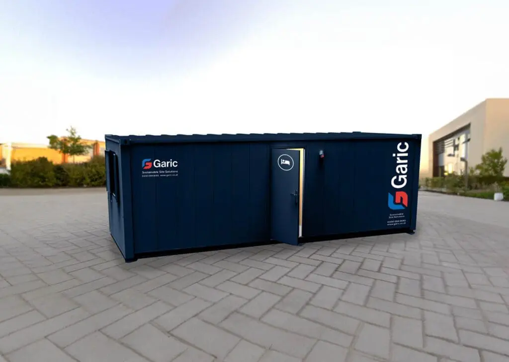 A Sleeper Cabin 24, featuring Garic branding in blue with an open door, is positioned outdoors on a paved surface.