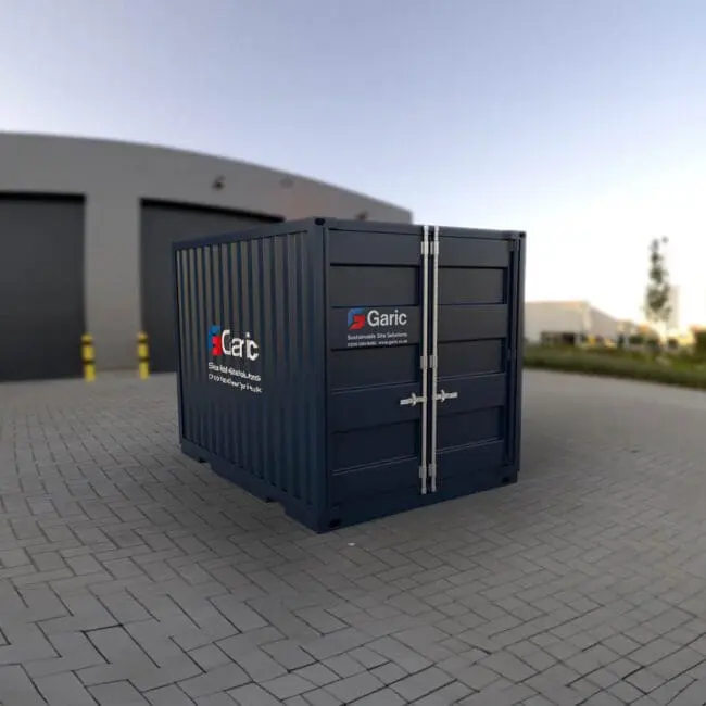 A blue Steel Storage Container is placed on a paved area in front of a large industrial building.