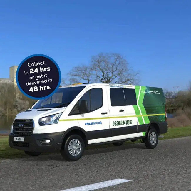 A Welfare Van Eco+ in white and green is driving on a road by a river, with a blue sky in the background.