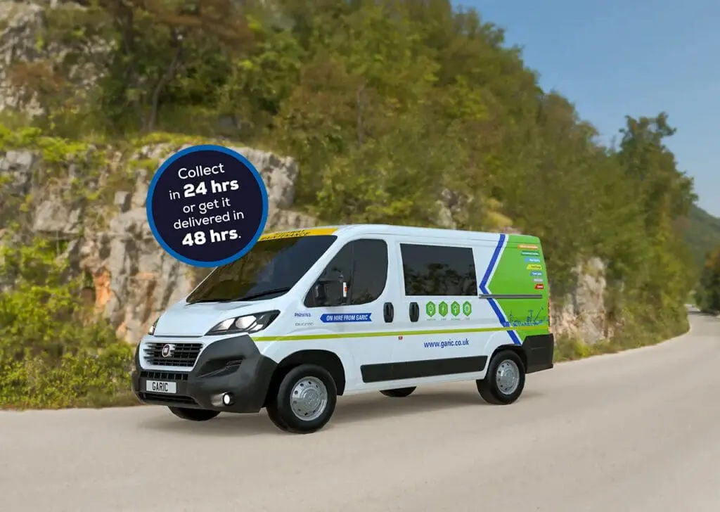 A Welfare Van Eco drives down a road beside a sign that reads “Collect in 24 hrs or get it delivered in 48 hrs.”.