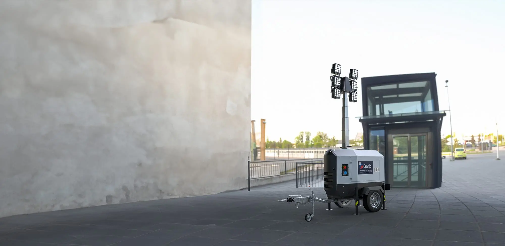 An Eco Tower Light is positioned on a paved area near a modern glass building.