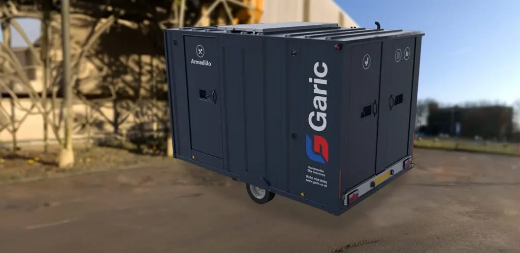 Dark blue Armadillo 12 Eco unit with doors and logos, positioned on an outdoor industrial site.