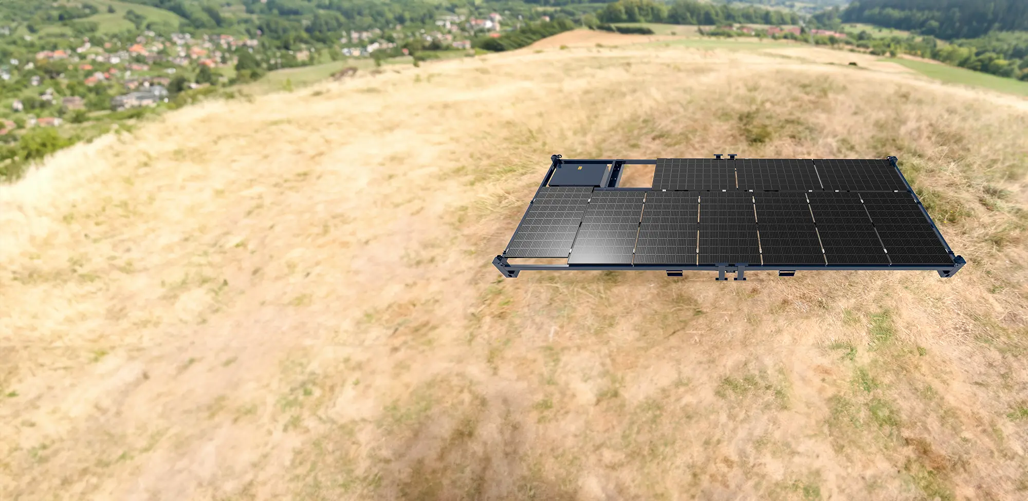 A Solar Power Frame is installed on a dry, grassy hillside overlooking a valley with houses and trees.