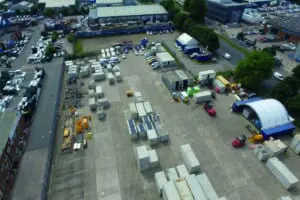 Aerial view of an industrial storage yard with shipping containers and machinery.