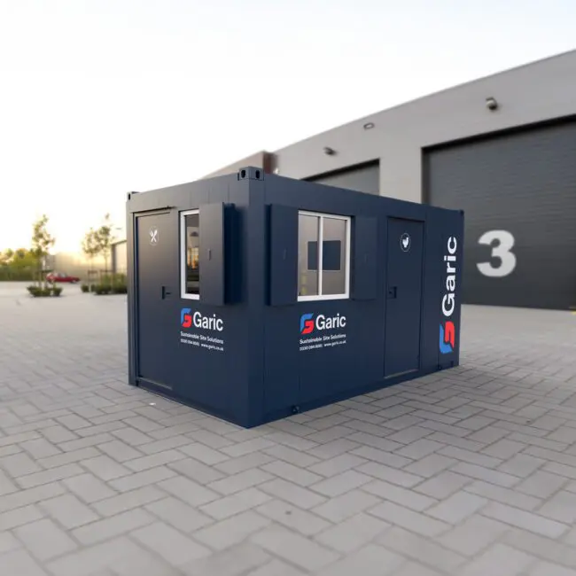 Combi Junior 15 portable office container with Garic logo outside a warehouse with large numbered doors.