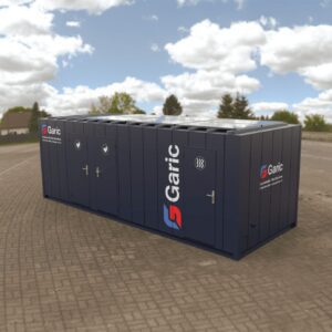 The 2+1+Dryer 24 Eco portable toilet and shower unit in dark blue is set up on a paved outdoor area under a cloudy sky.