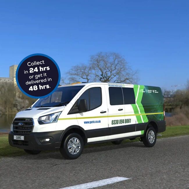 A Welfare Van Eco+ in white and green is driving on a road by a river, with a blue sky in the background.